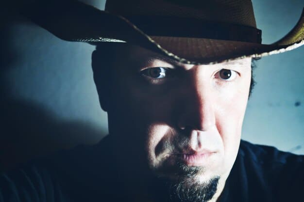 A close-up shot of a weathered cowboy's face, with intense eyes and a determined expression, symbolizing the resilience and grit of the characters in the upcoming Western films.