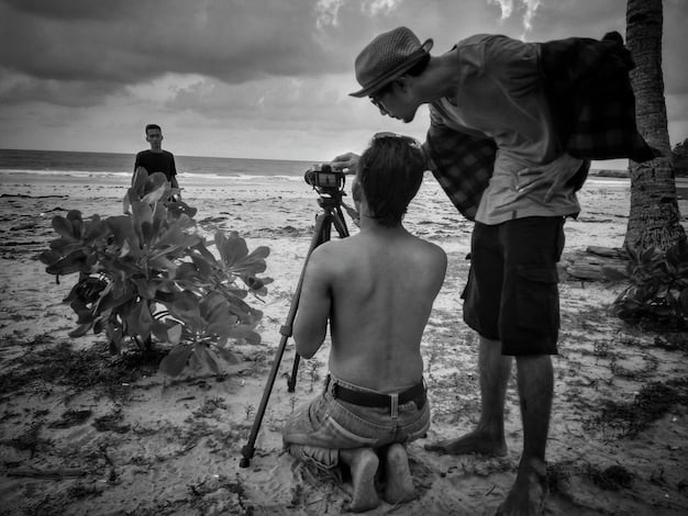 A wide shot capturing a film set in Recife, Brazil, with Kleber Mendonça Filho directing a scene. The photo showcases actors in costume, the film crew around them, and the urban landscape of Recife in the background. The lighting is natural, emphasizing the everyday feel of the cinematic process.