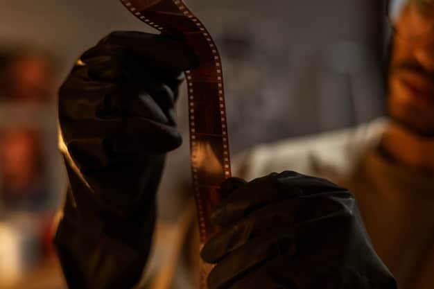 A close-up shot of a person's hands carefully handling a film reel, with archival gloves on. The focus is on the delicate nature of the film and the precision required during the preservation process. The background is slightly blurred to emphasize the film reel.