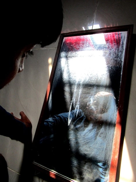 A person wearing archival gloves operating a high-resolution film scanner. The focus is on the scanner and the person's careful operation of the equipment. The background is a modern film archive laboratory.